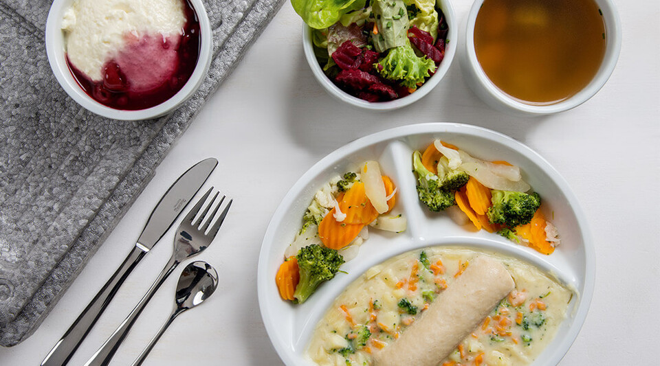 Teller mit warmem Essen, Suppe und Salat für den Mahlzeitendienst.